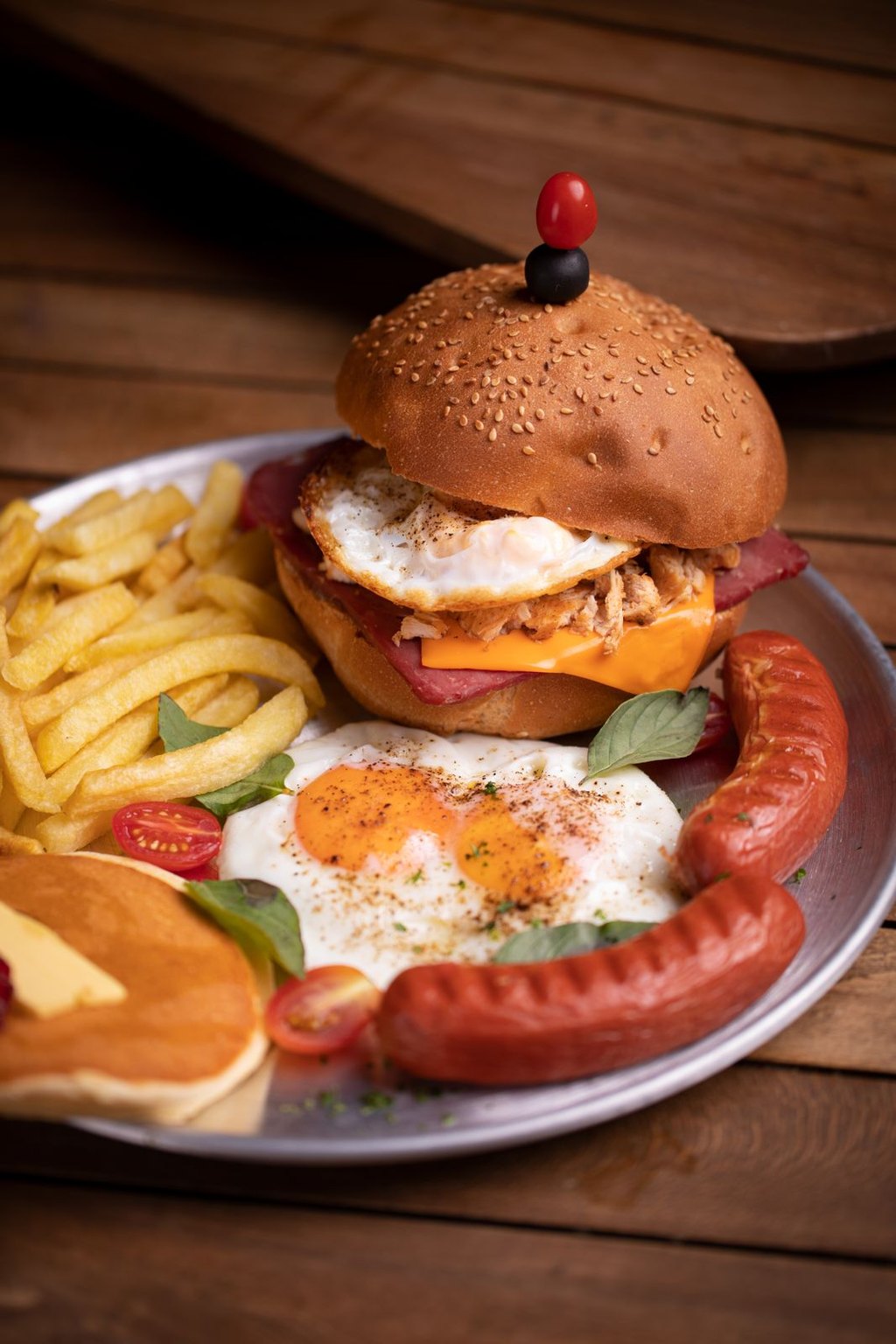 Burger śniadaniowy z jajkiem i kiełbaskami