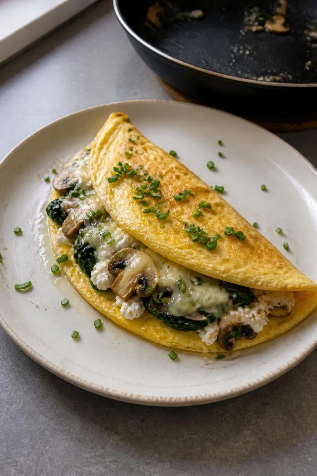 Francuski omlet z serkiem, szpinakiem i pieczarkami